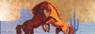 Two horses rearing in a desert landscape with cacti and a building.