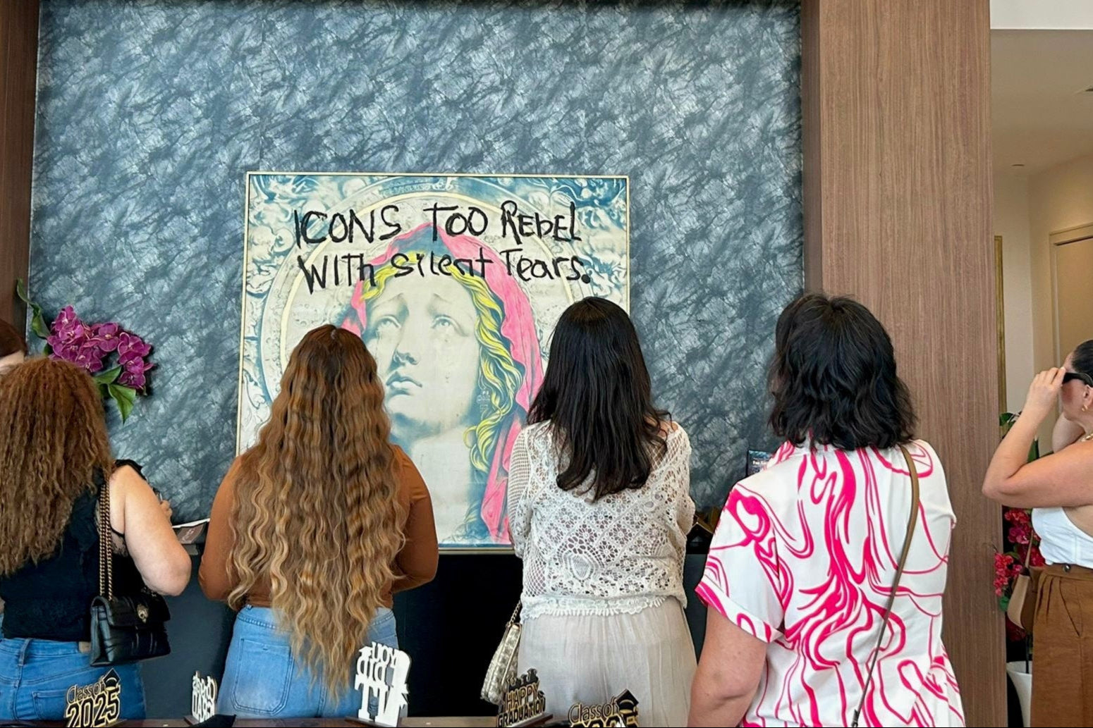 Group of people observing a papayon painting in an art gallery.